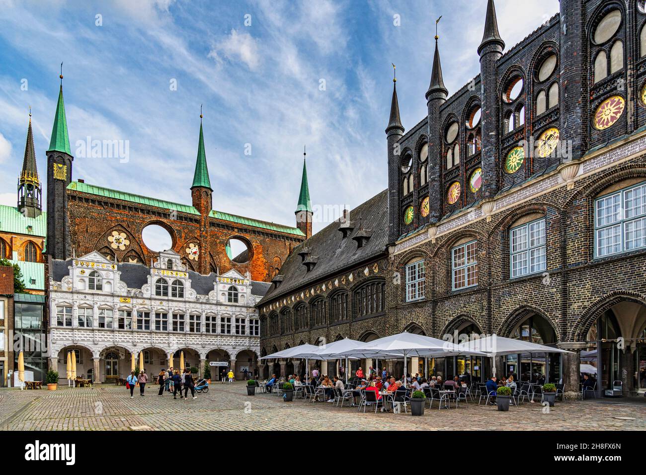 The buildings of the town hall of Lübeck, in the historic center of the city, frame the market square visited by tourists. Luebeck, Germany Stock Photo