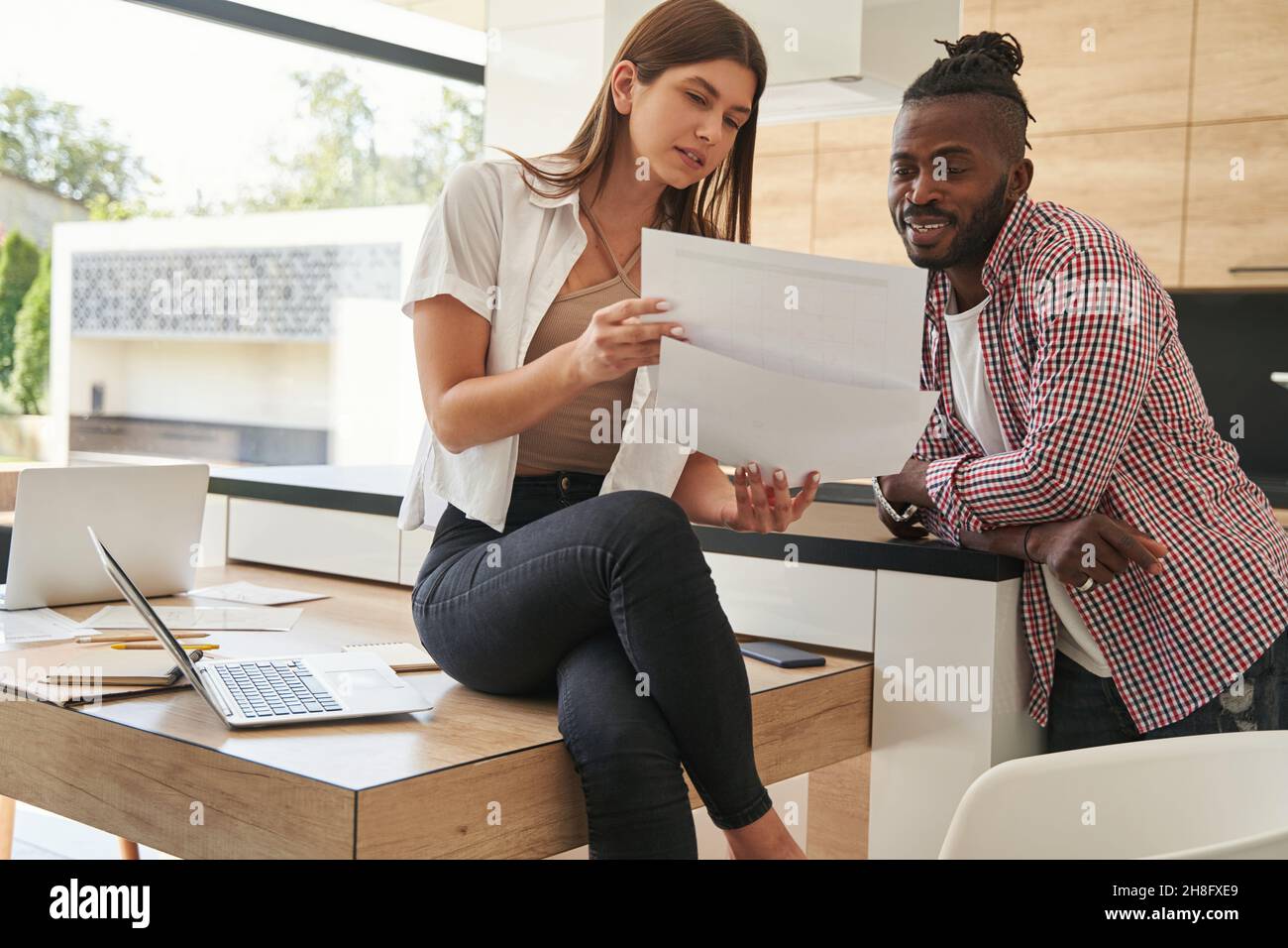 Focused woman and pleased man scrutinizing documents Stock Photo