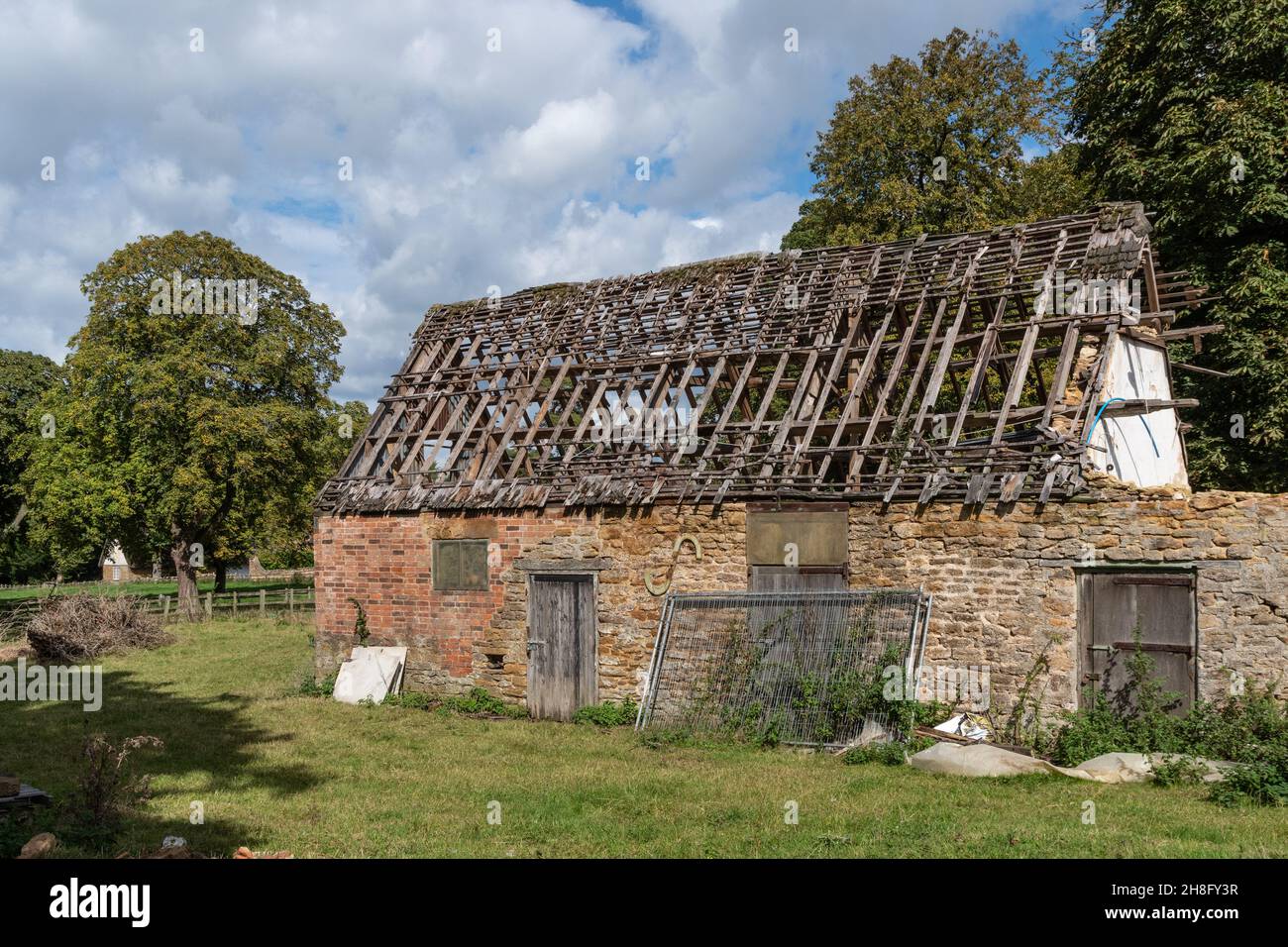 Dilapidated old barn, missing its roof tiles, in the village of Ashby St Ledgers, Northamptonshire, UK Stock Photo