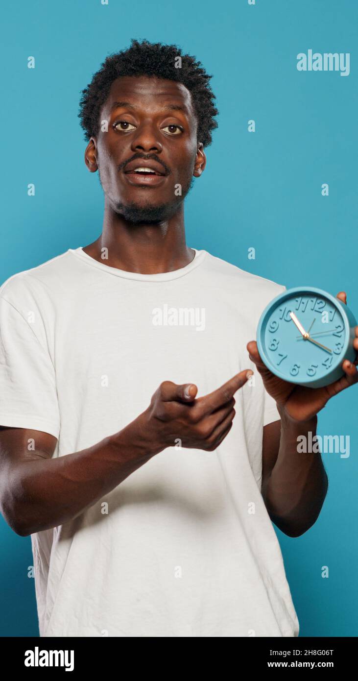 Pointing At Time Casual person pointing at time on wall clock for hour and minutes ...