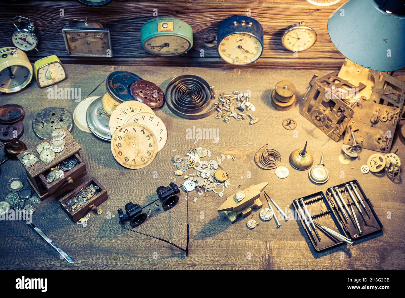 Aged watchmaker's with repaired clocks. Ancient watchmaker's