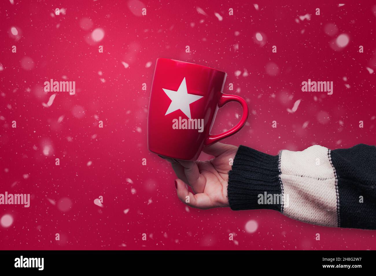 Red Christmas mug with red snowy background. Christmas concept design. Stock Photo