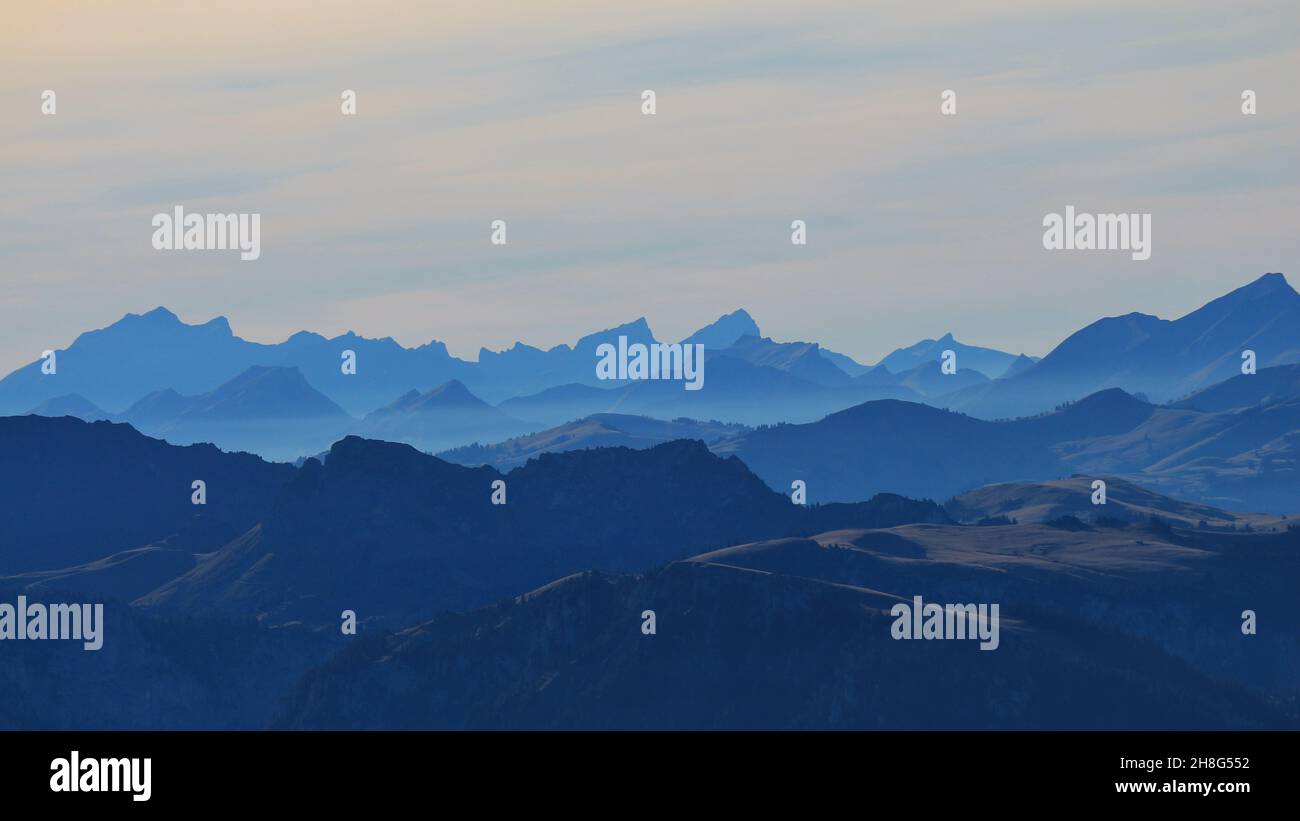 Blue silhouettes of mountains in the Bernese Oberland. Stock Photo