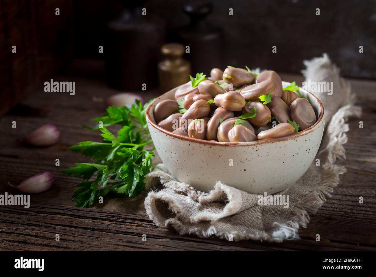 Healthy boiled broad beans with garlic and parsley. Summer bowl full of