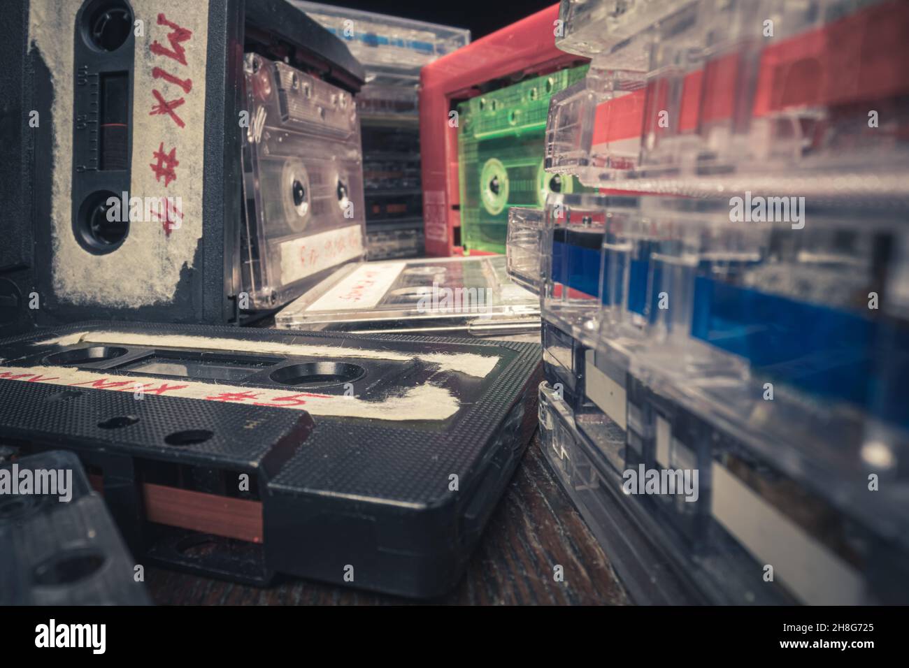 Stack of cassettes and one spinning in player. Old cassette and player