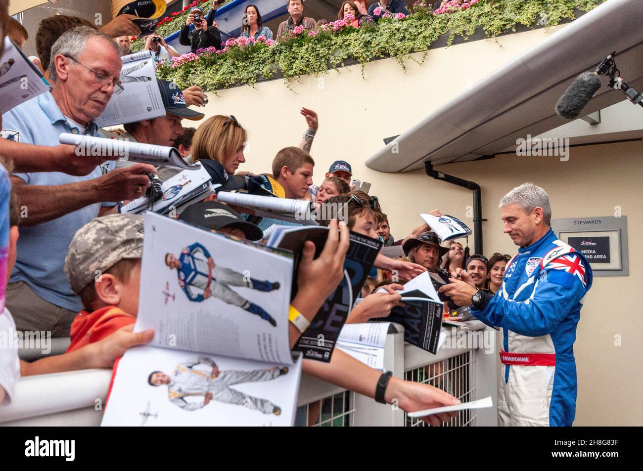Winner Paul Bonhomme signing autographs after the Red Bull Air Race at Royal Ascot 2015. Autograph hunters. Autographing event programmes. Fans Stock Photo