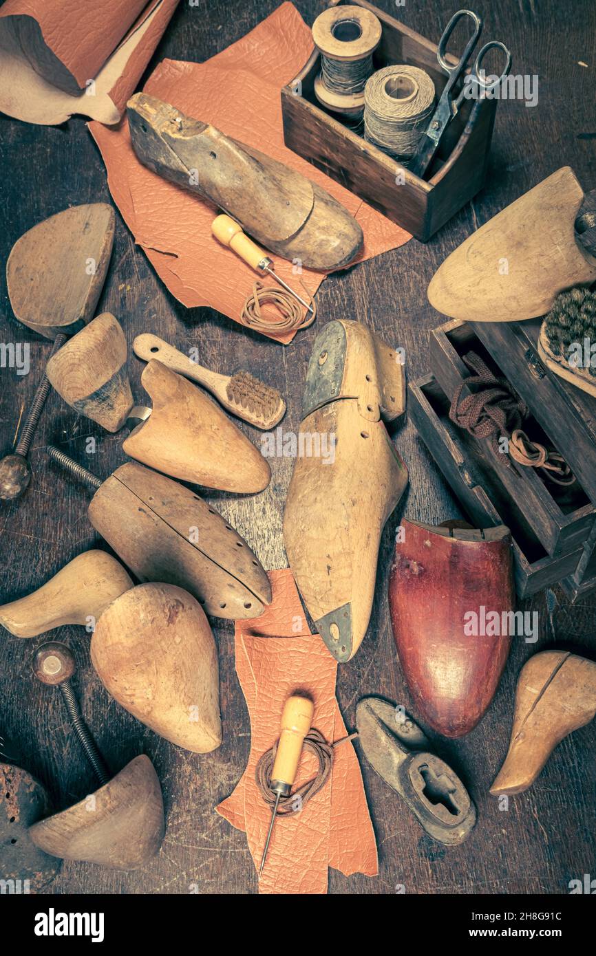 Old shoemaker with with tools, anvil, shoes and rule. Old shoemaker Stock
