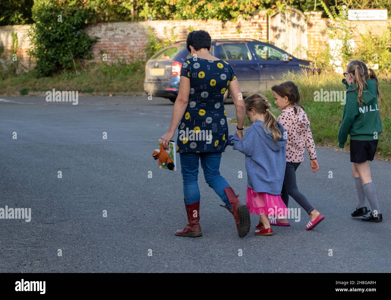 A woman three young girls going home after a mini poetry festival in a Suffolk village Stock Photo
