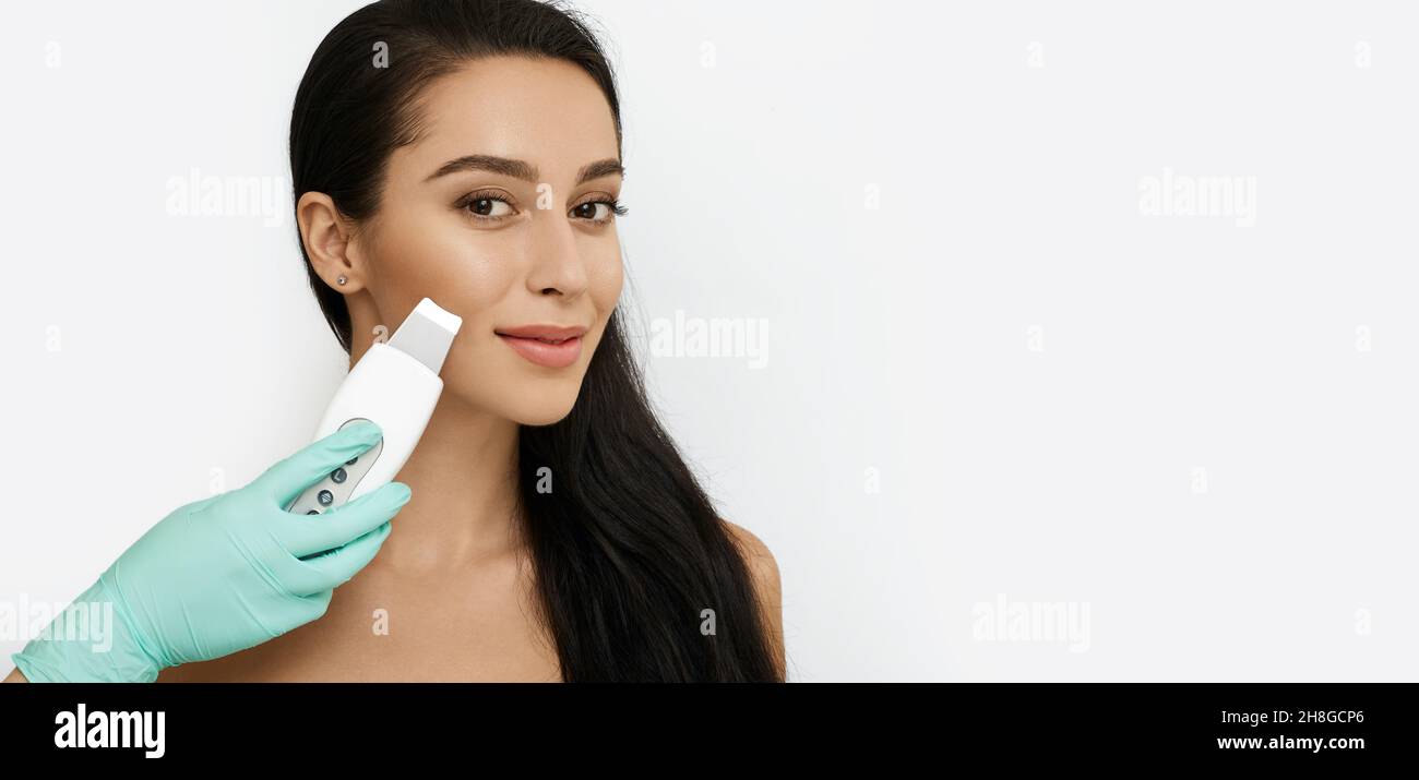 Beautiful woman while ultrasonic peel skin procedure. facial skin care, cleansing facial skin, isolated Stock Photo
