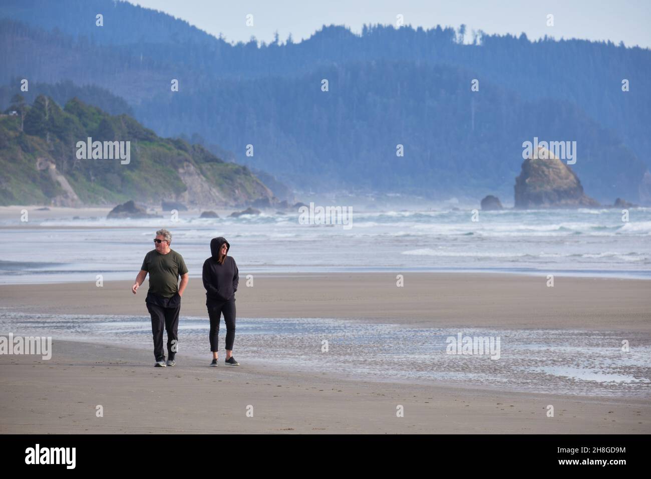 People walking by the ocean near Cannon beach, Oregon Stock Photo