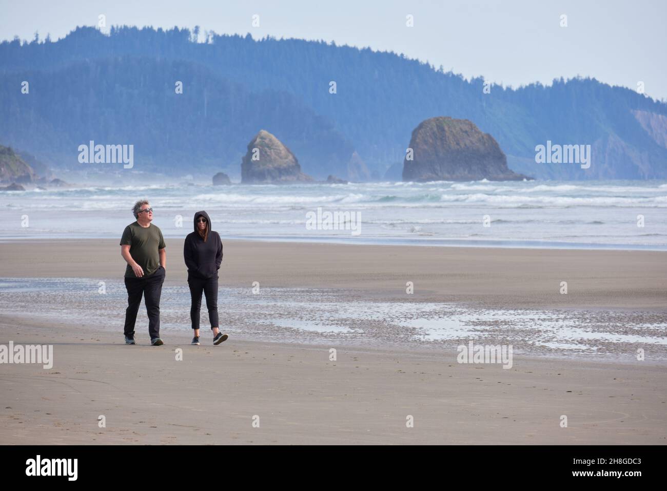 People walking on the Pacific Ocean beach near Cannon beach, Oregon Stock Photo