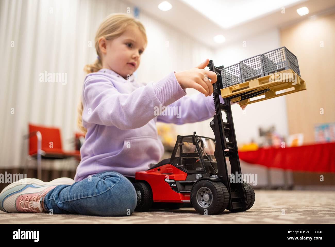 Nuremberg Germany. 30th Nov 2021. Luisa plays with the Linde HT160 stacker from BRUDER Spielwaren GmbH Co.KG at a toy industry press conference. The toy industry presented the figures for 2021 and