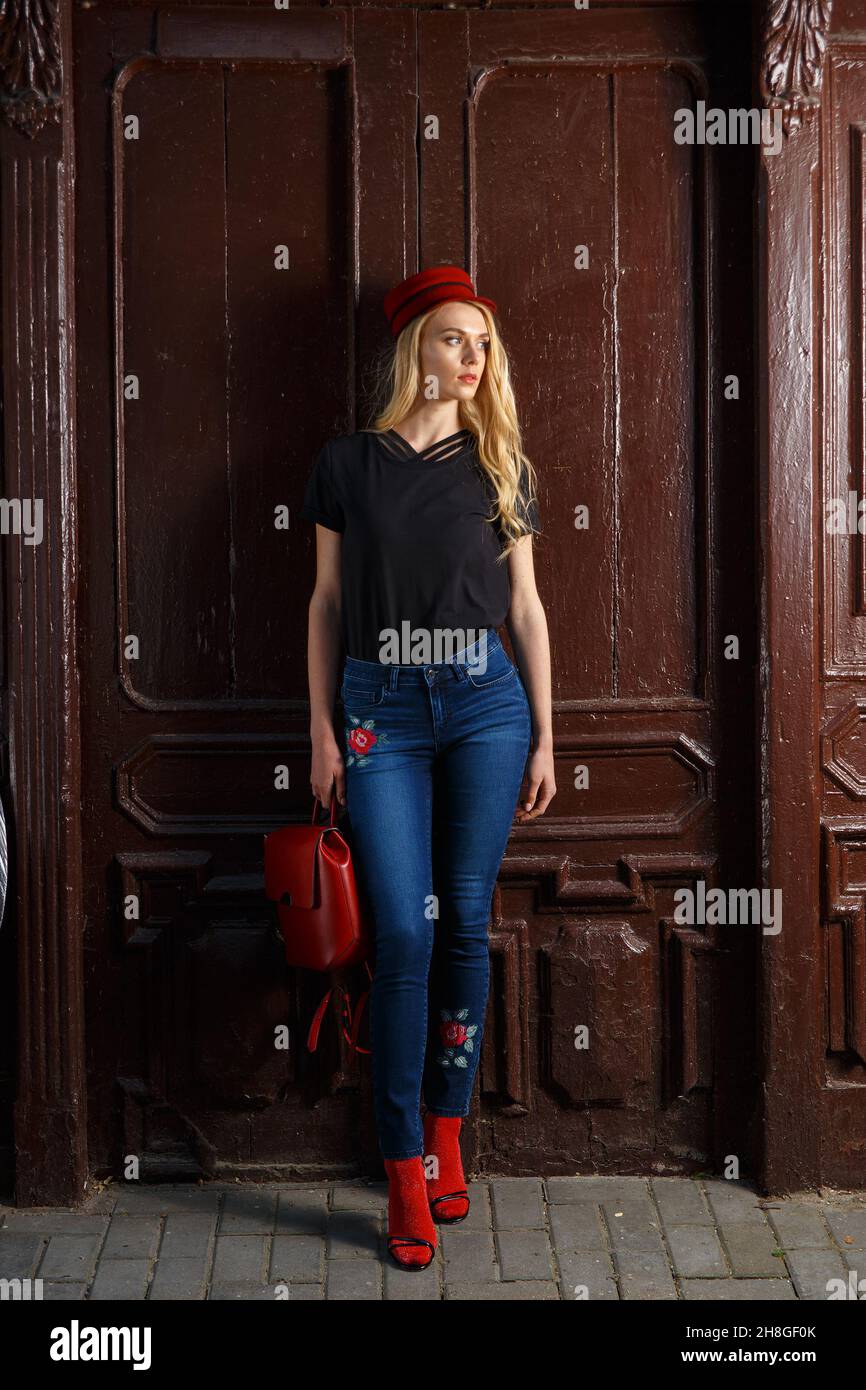 Full length image of fashionable woman on a street. amazing trendy skinny blue black shirt and red shoes and hat Stock Photo - Alamy