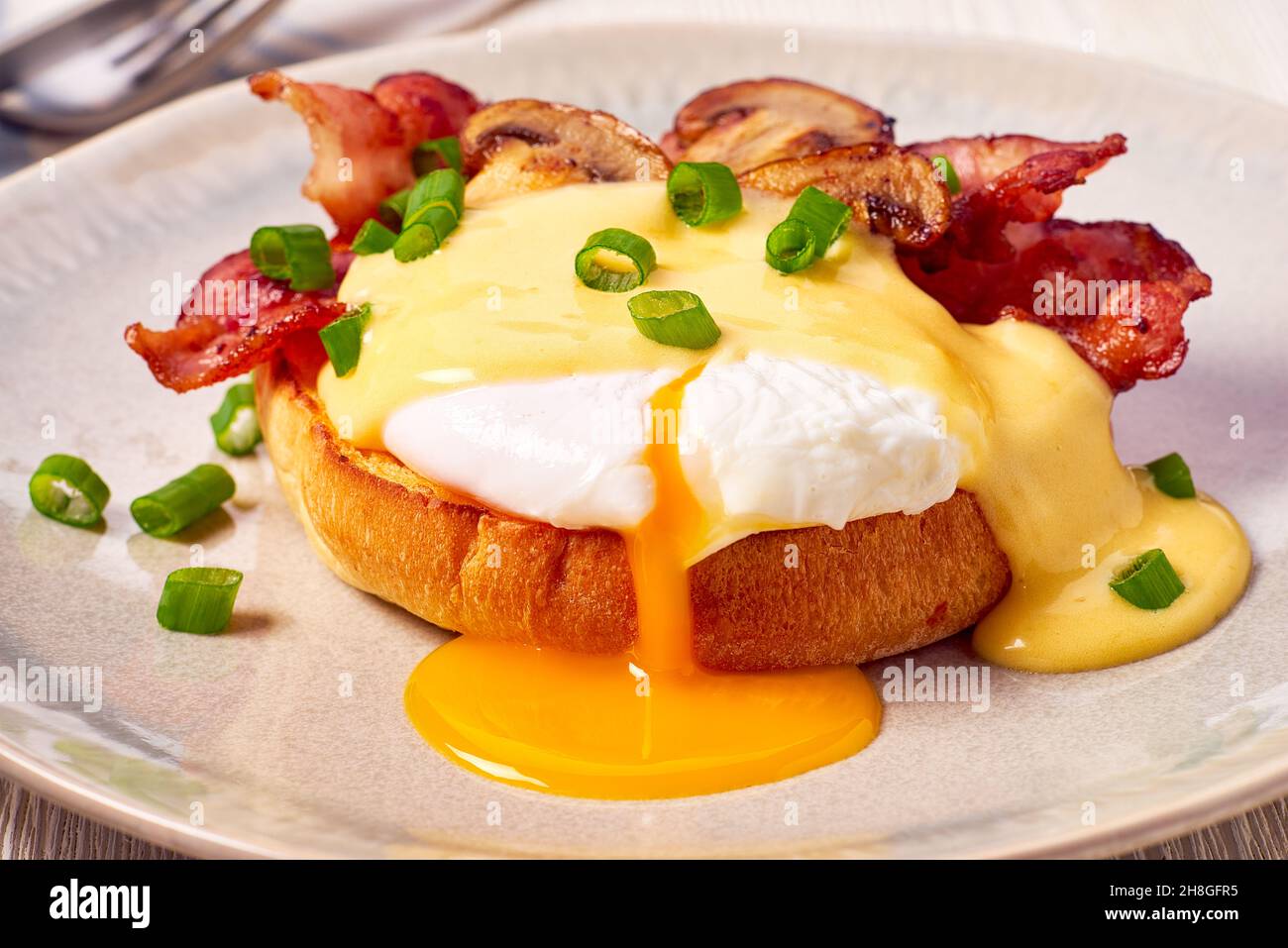 Egg Benedict with fried bacon and hollandaise sauce Stock Photo