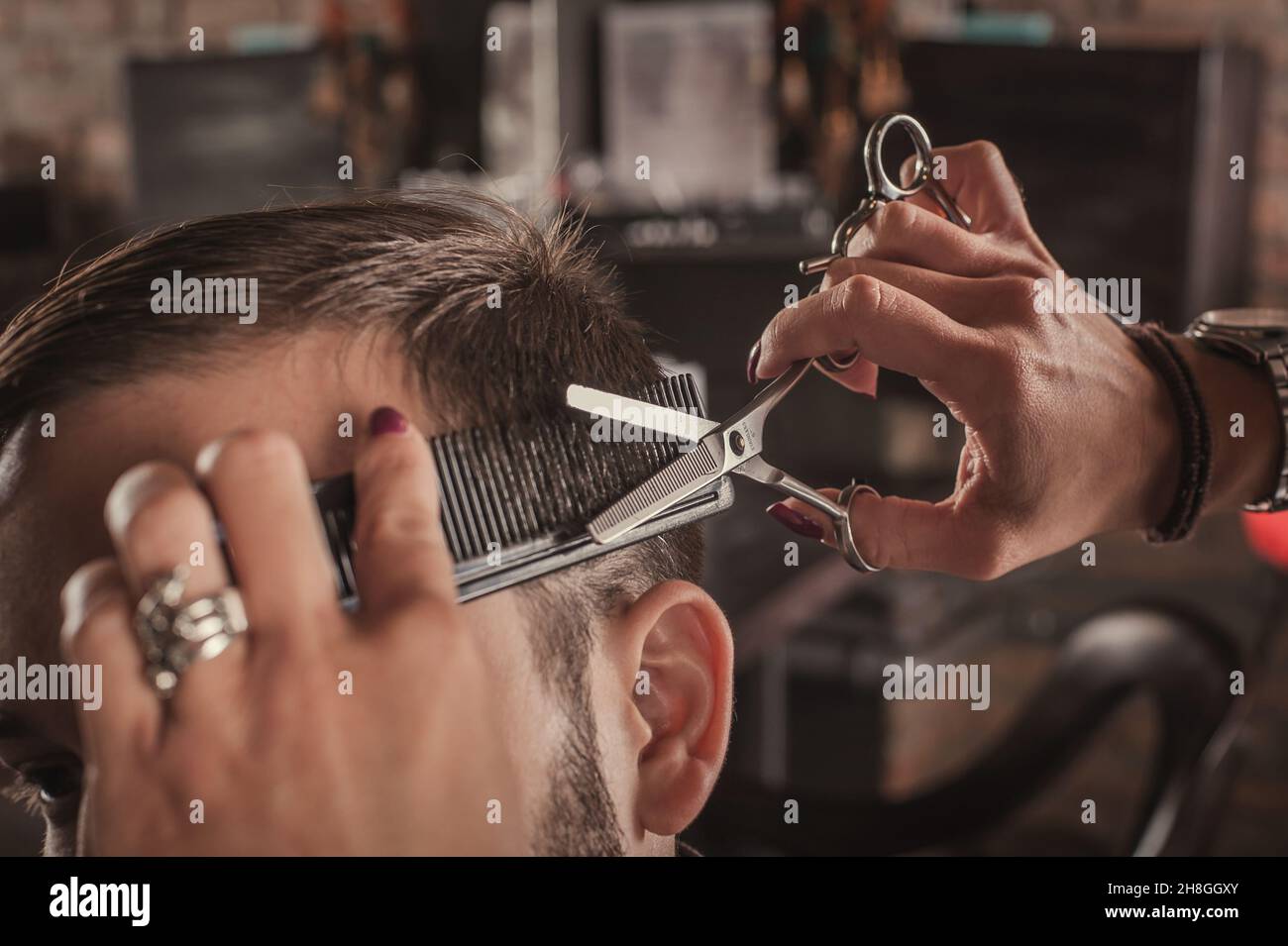 Skillful female hairdresser hairstyle hair of attractive man in hair salon.  Close up Stock Photo - Alamy