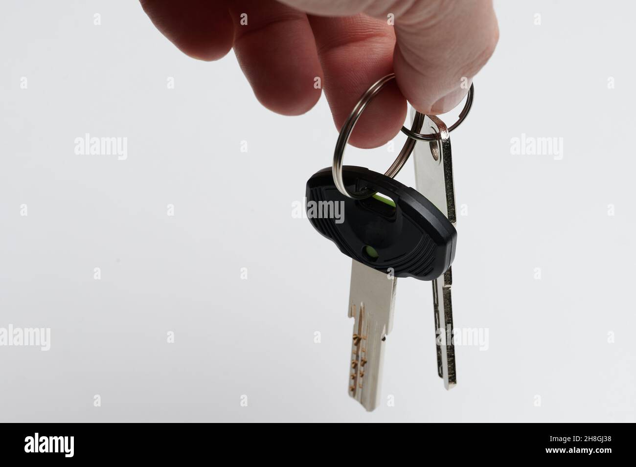 Real estate sale theme. Two metal keys hang on rings isolated Stock Photo
