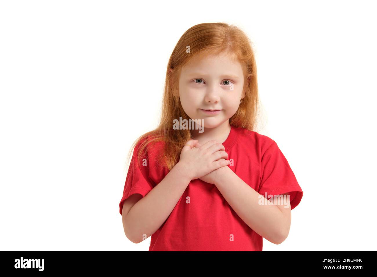 Portrait of cheerful caucasian little girl with red hair posing in studio with looking to the camera. Stock Photo