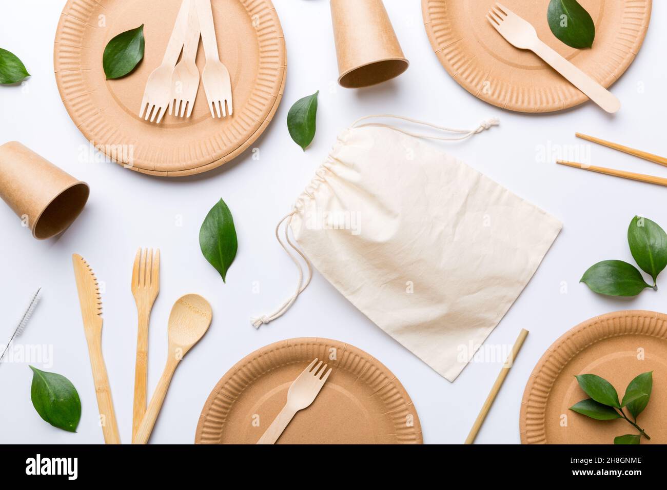 set of empty reusable disposable ecofriendly plates, cups, utensils on light white colored