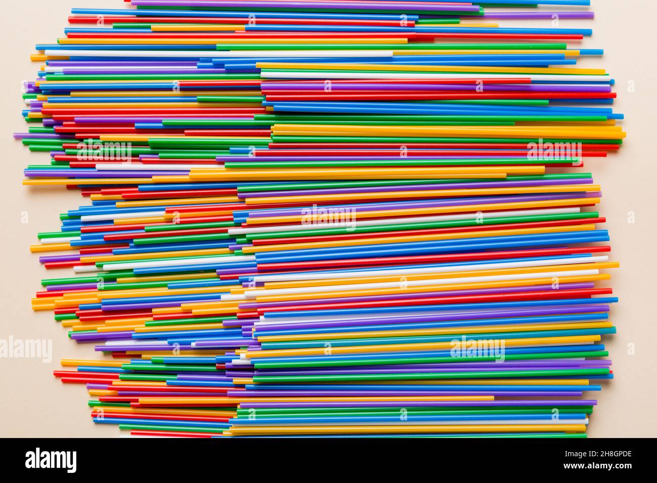 many multi-colored plastic tubes for cocktail on Colored background, top view. Stock Photo