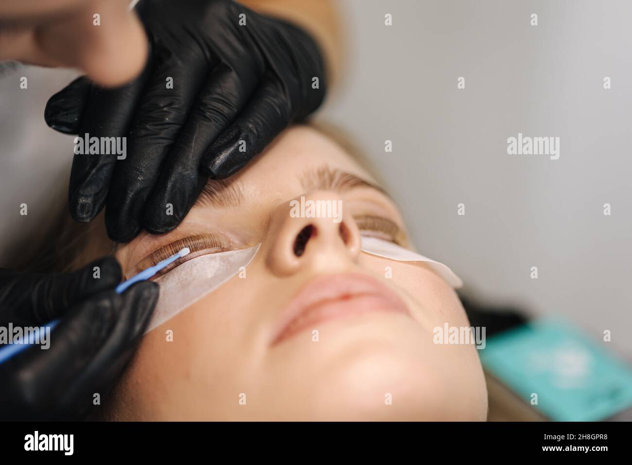 Closeup of eyelash care treatment procedures. Beautiful female, blond