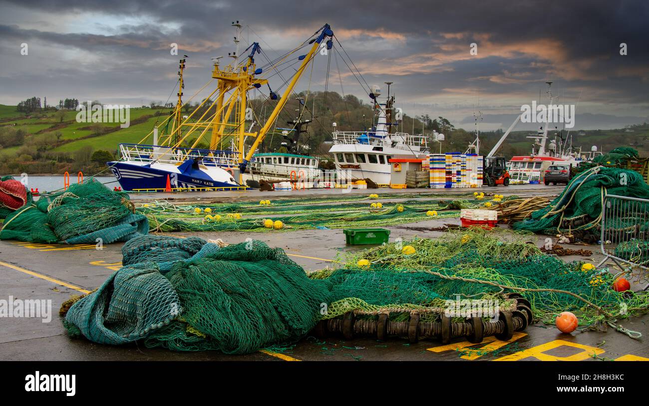 Beam Trawler moored up under stormy skies with fishing nets on a pier. Stock Photo