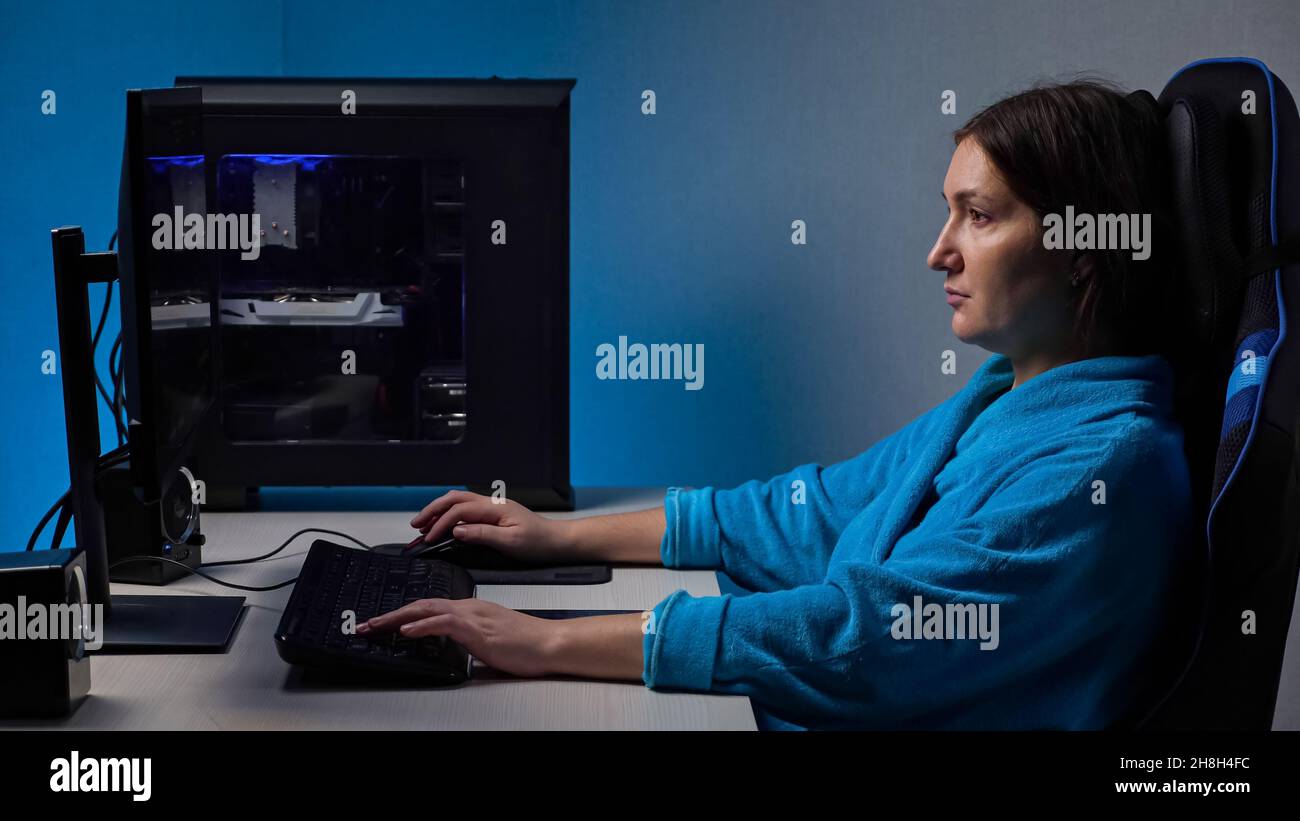 Young woman plays computer game sitting in comfy chair Stock Photo - Alamy