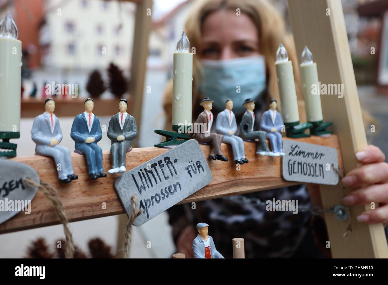 Wernigerode, Germany. 30th Nov, 2021. Ilka Hoffmann-Woyde decorates a rung ladder in front of her shop. Hope and confidence are to be spread by the creatively and Christmassy decorated rung ladders in Wernigerode's city centre. For the second time in a row the shops and retailers decorate themselves again with self-designed rung ladders and provide a special eye-catcher. The campaign 'Wintersprossen' was initiated by the city of Wernigerode and the merchants' guild. Credit: Matthias Bein/dpa-Zentralbild/ZB/dpa/Alamy Live News Stock Photo