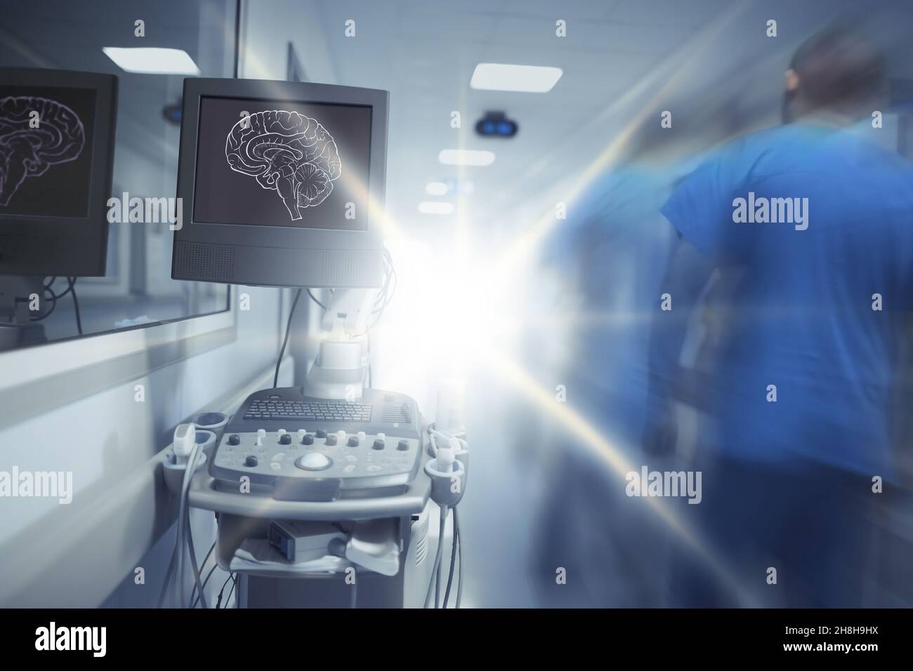 Blurred figure of male doctor walking into the flashing light in the hospital hallway. Stock Photo