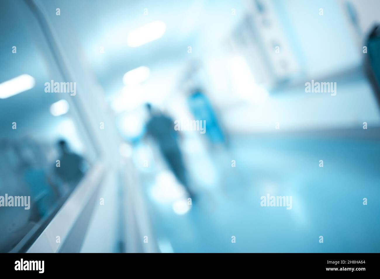 Obscure figure walking through the hospital corridor, unfocused background. Stock Photo