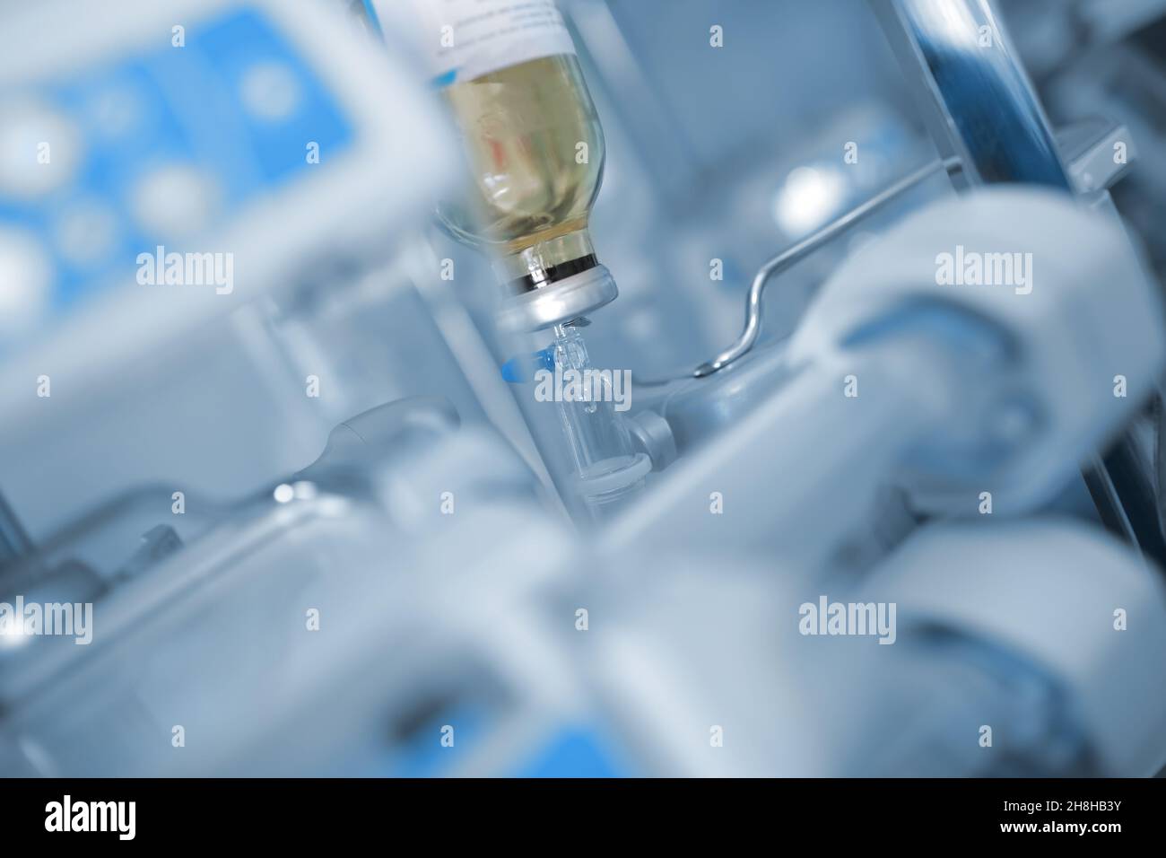 Glass bottle with a solution hanging in the ward on the background of equipment. Stock Photo