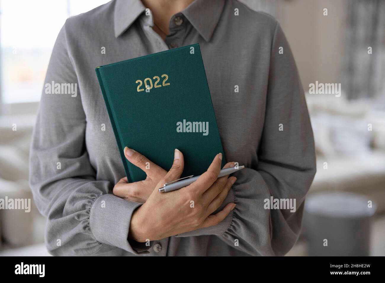 Close Up Of Woman Holding New Year 2022 Diary At Home Stock Photo