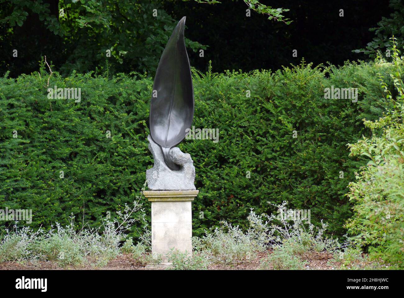 Bronze Leaf Sculpture on Stone Plinth in a Corner of the Gardens at Newby Hall & Gardens, Ripon, North Yorkshire, England, UK. Stock Photo