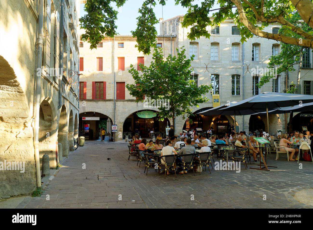 France, Gard, Pays d'Uzege, Uzes, the Place aux Herbes surrounded by arcaded houses and its outdoor cafes Stock Photo