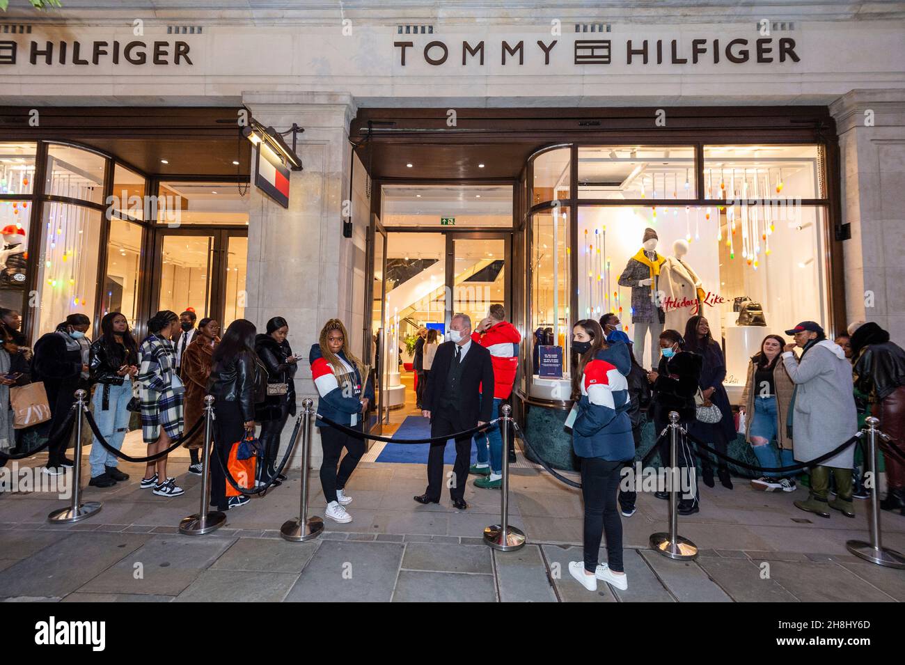 London, UK. 30 November 2021. Invited guests and 'influencers' wait to  enter the Tommy Hilfiger store on Regent Street. They will see a public  appearance inside with designer Tommy Hilfiger and Nigerian