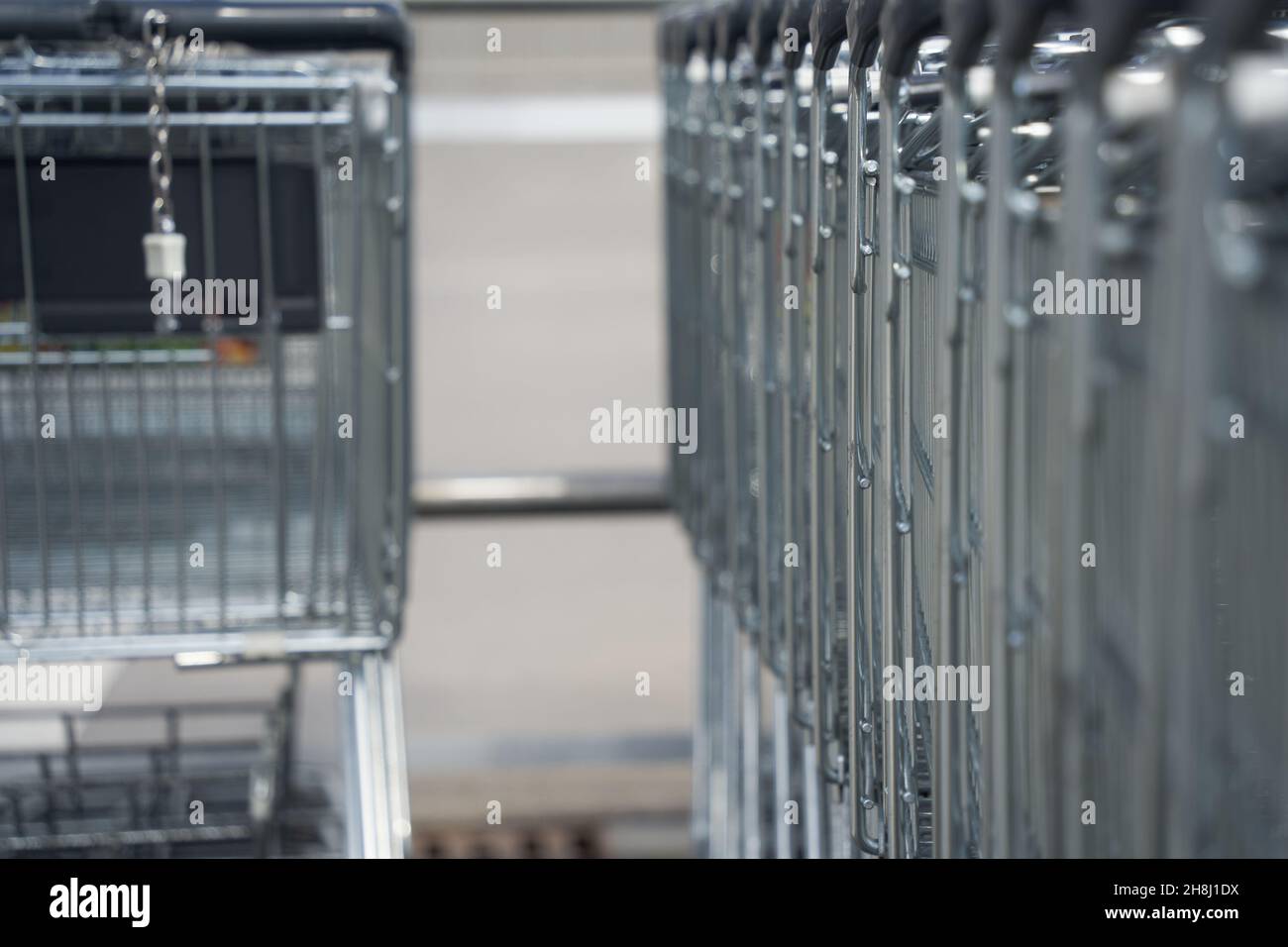 2 rows with shopping carts. Chain from deposit lock hangs down. Somewhere in Germany. Stock Photo