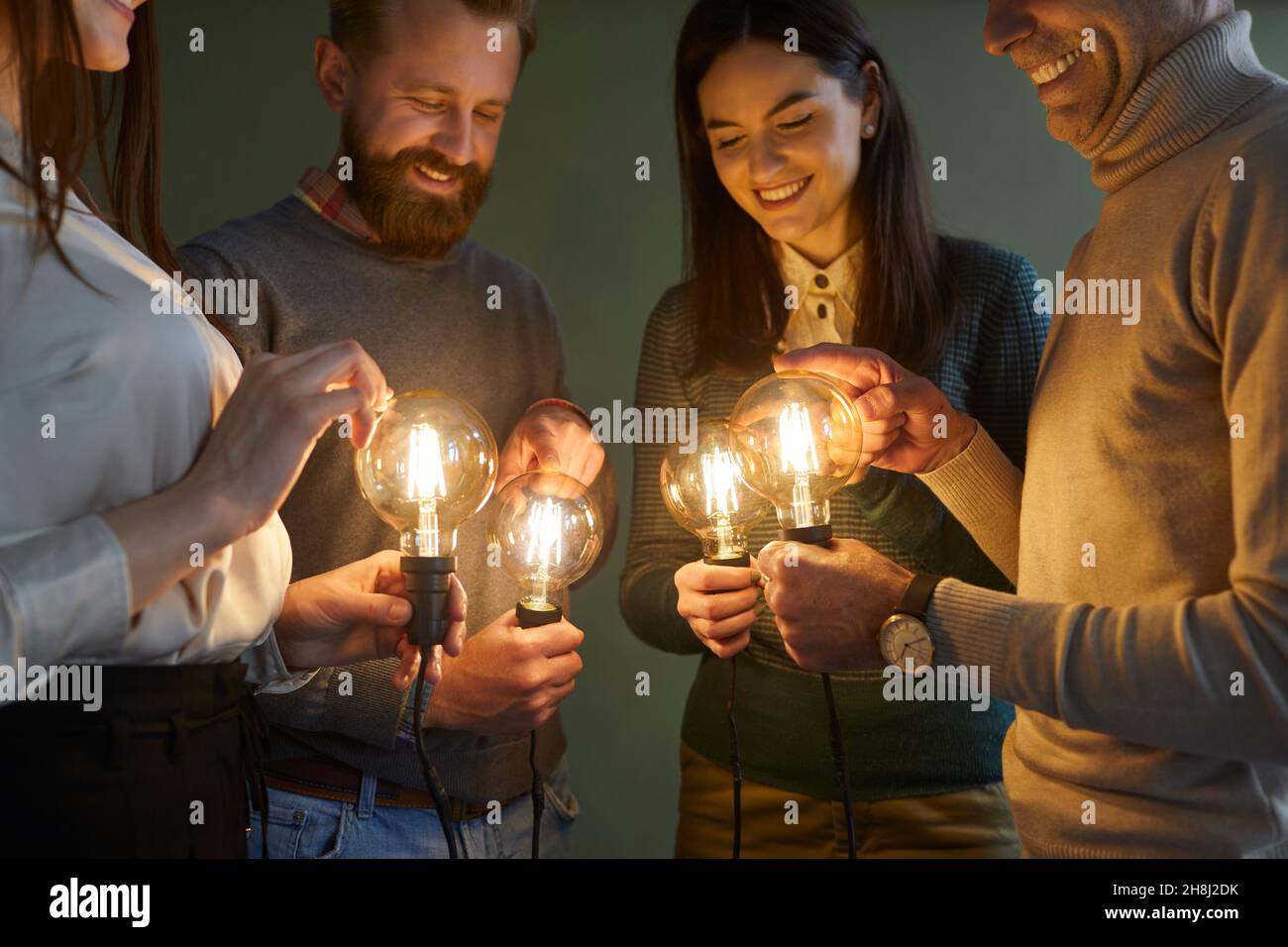 Group of people holding electric light bulbs to illuminate concept of idea and innovation Stock Photo