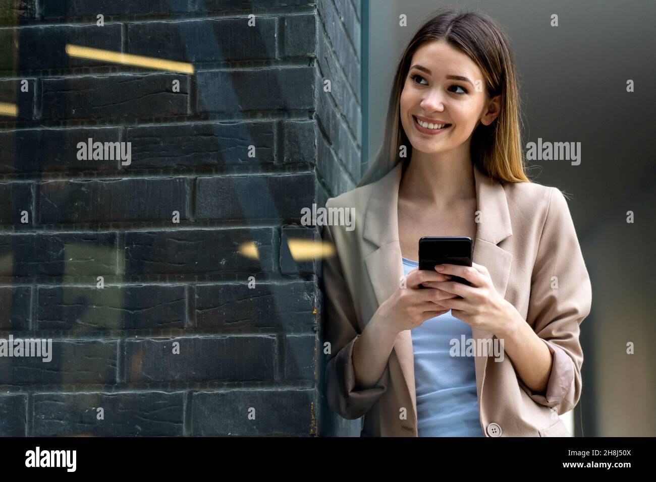 Portrait of successful woman with mobile in urban background. Business technology device concept Stock Photo