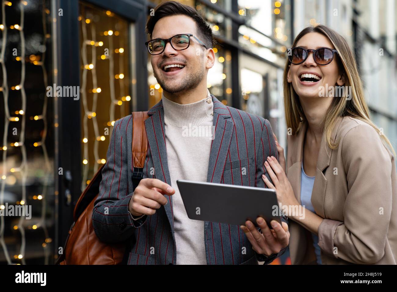 Portrait of two smiling business people walking and talking together in ...