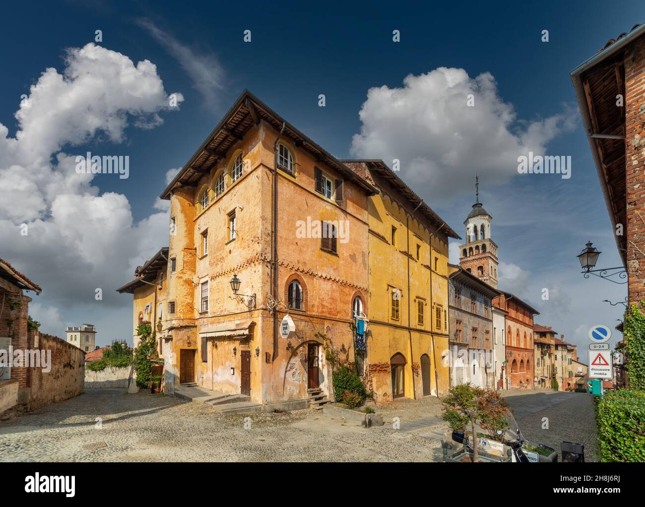 Saluzzo, Cuneo, Italy - October 19, 2021:  Salita al Castello street with ancient colorful historic buildings and in the background the civic tower (X Stock Photo