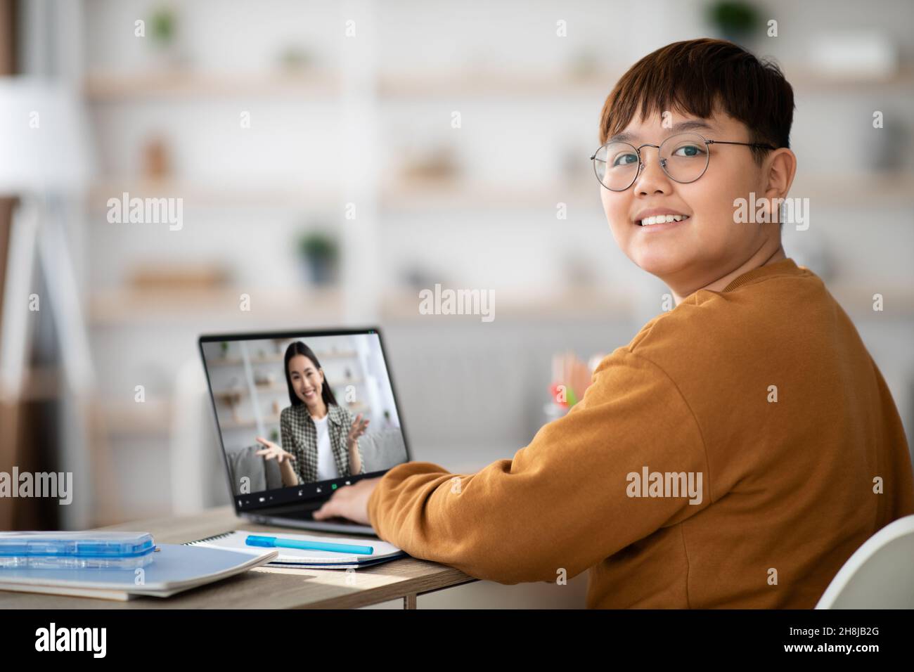 Cute chubby boy having online class with teacher Stock Photo