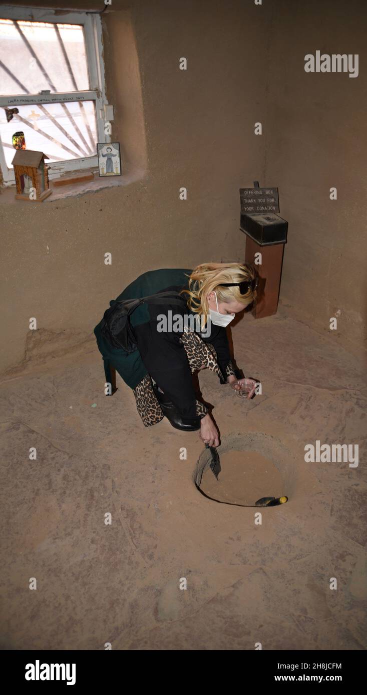 A tourist collects "holy dirt" in the historic Santuario de Chimayo in