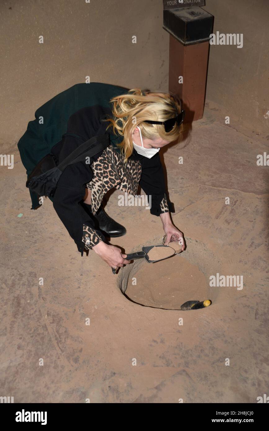 A tourist collects "holy dirt" in the historic Santuario de Chimayo in