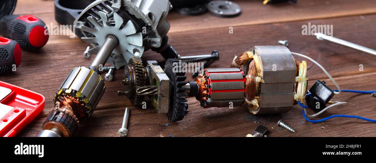 Details of electrical appliance and repair tools on a wooden table in a