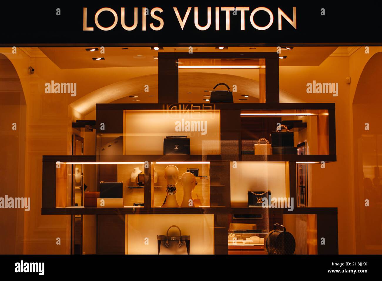 Louis Vuitton boutique with golden logo for advertising. Female fashion handbags at the display window. The company is one of the world's leading fash Stock Photo