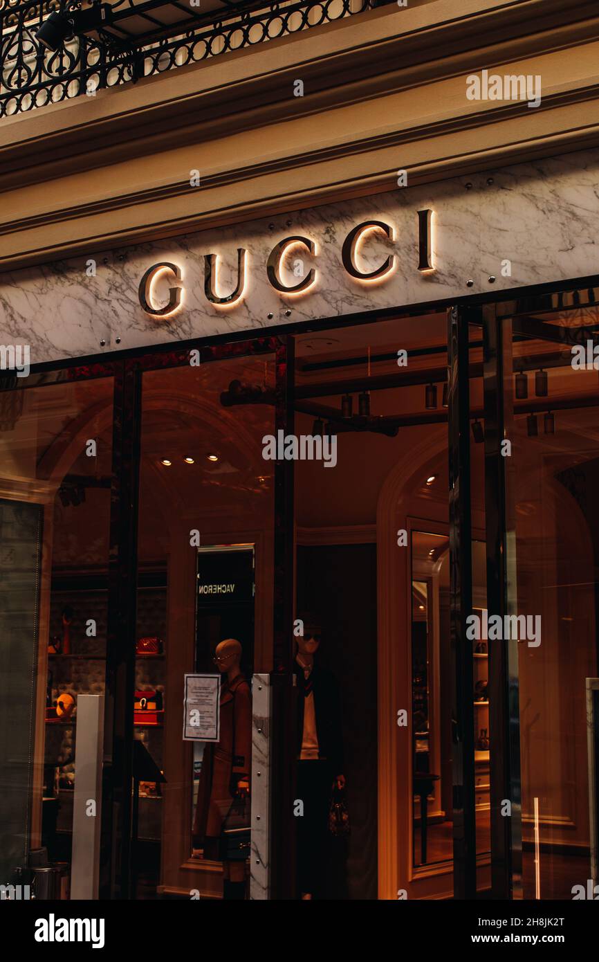 A window display at a Gucci store in Moscow. Gucci is an Italian luxury brand of fashion and leather goods with stores thought the world. Gold logo si Stock Photo