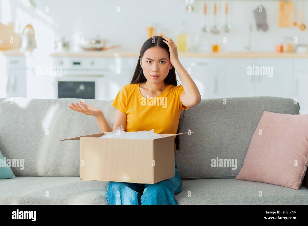 Bad delivery service. Dissatisfied young asian woman unpacking