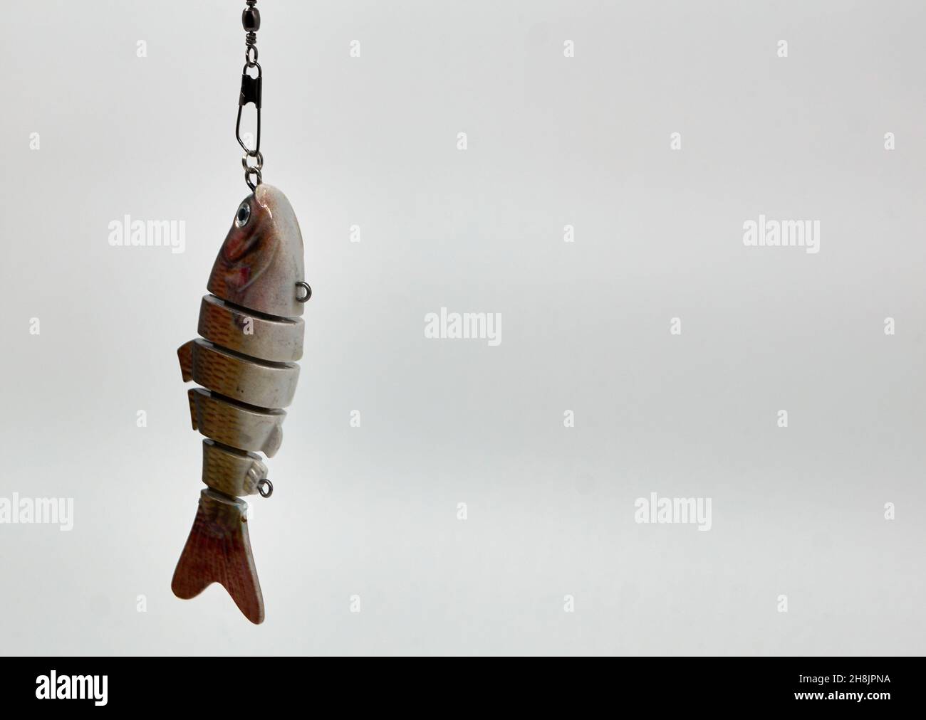 An artificial fish, used as bait by anglers on a white background. With