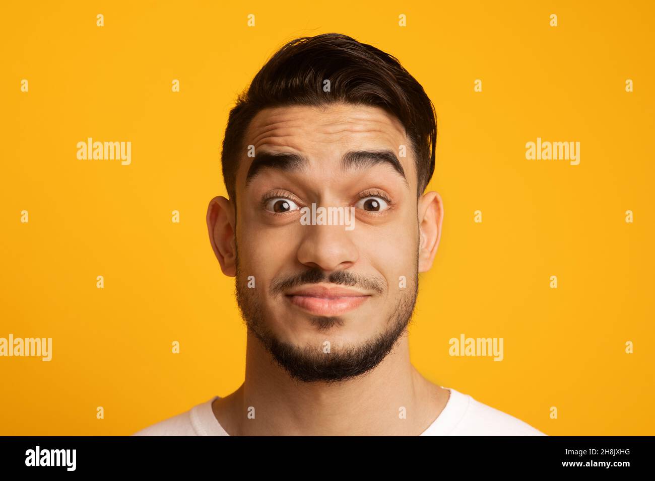 Surprised Young Middle Eastern Man Looking At Camera With Wide Open Eyes Stock Photo