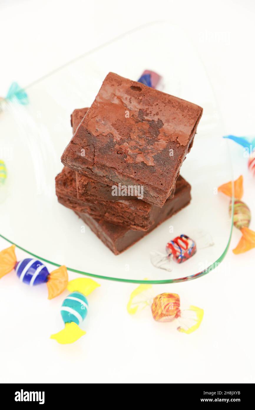 Stack of Brownies on glass plate with high key background and hard candy Stock Photo