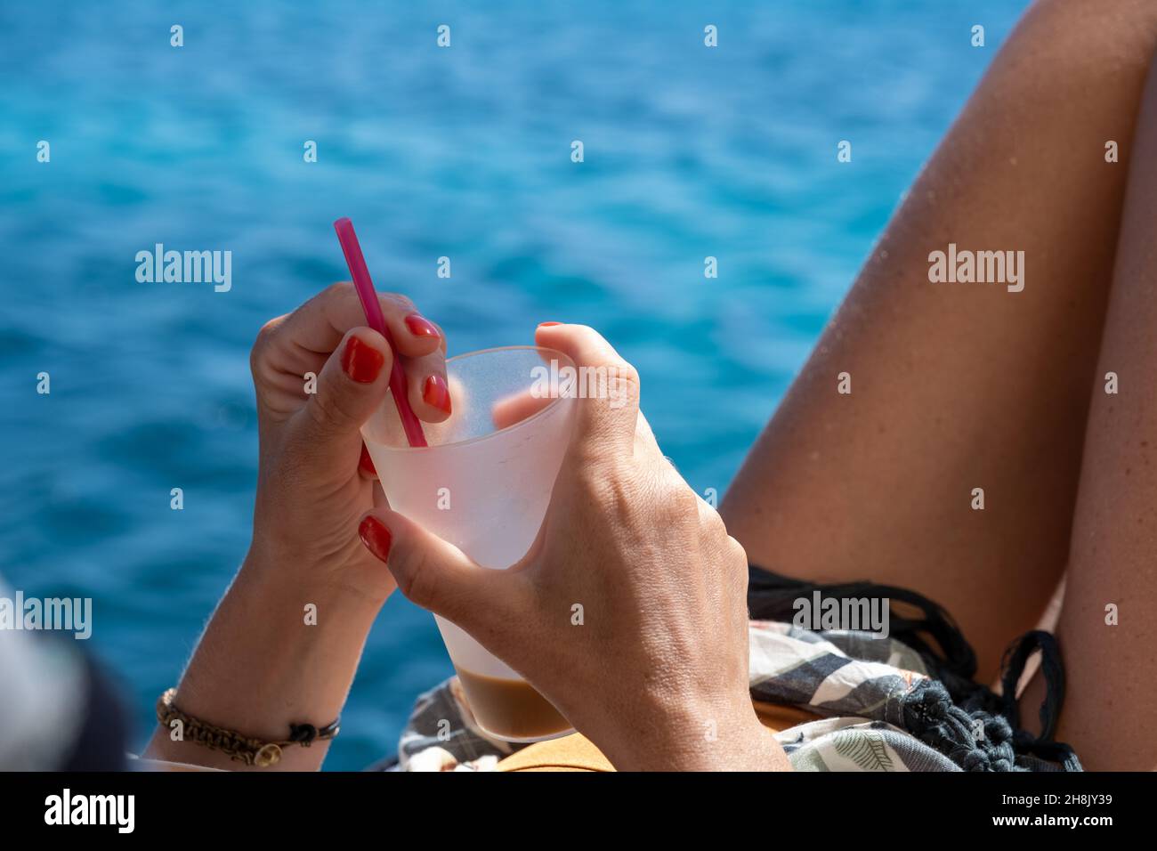 https://c8.alamy.com/comp/2H8JY39/womans-hand-holding-the-cocktail-glass-by-the-beach-2H8JY39.jpg